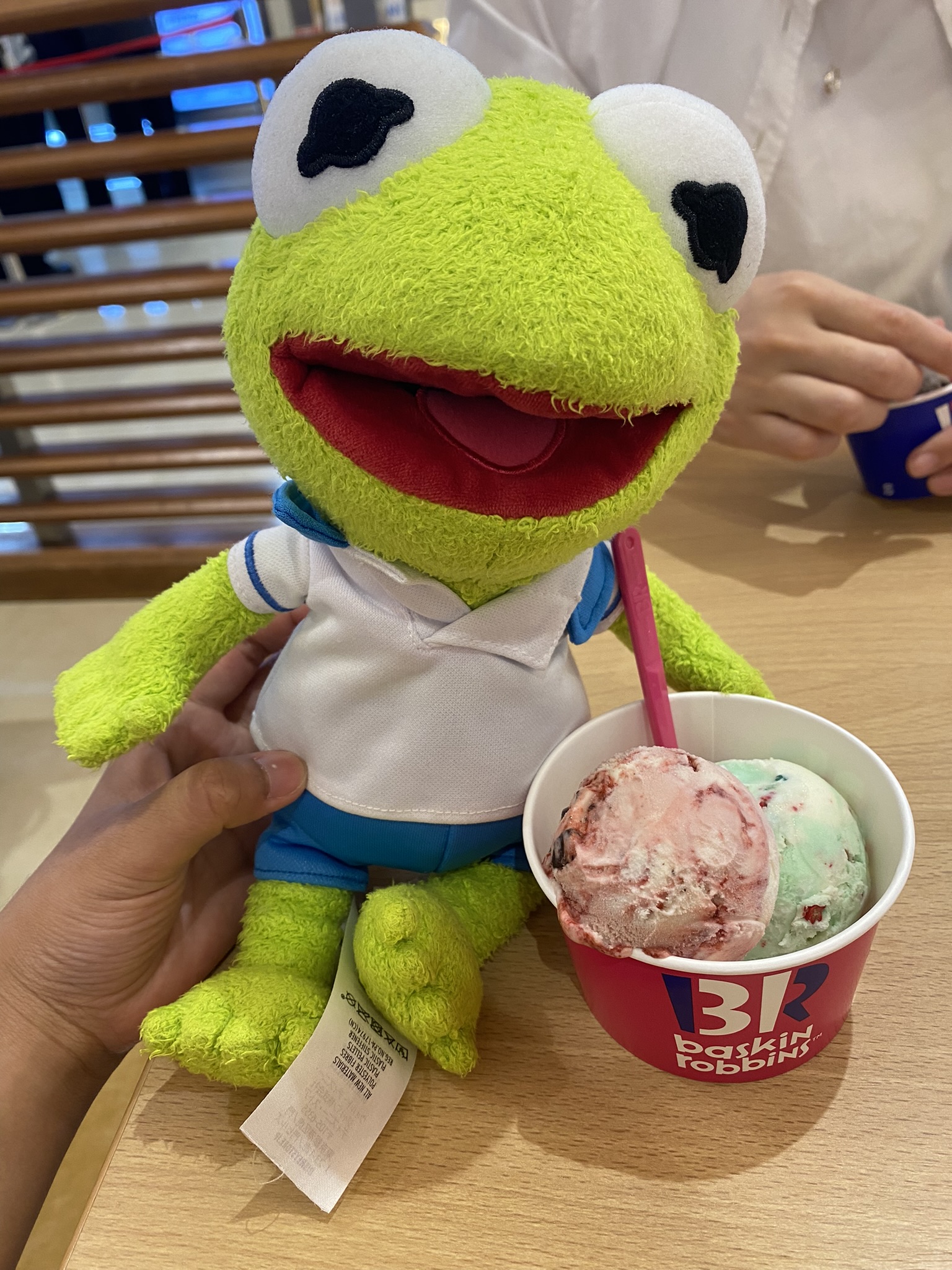 Kermit sitting next to a cup of Baskin Robin's Ice Cream.