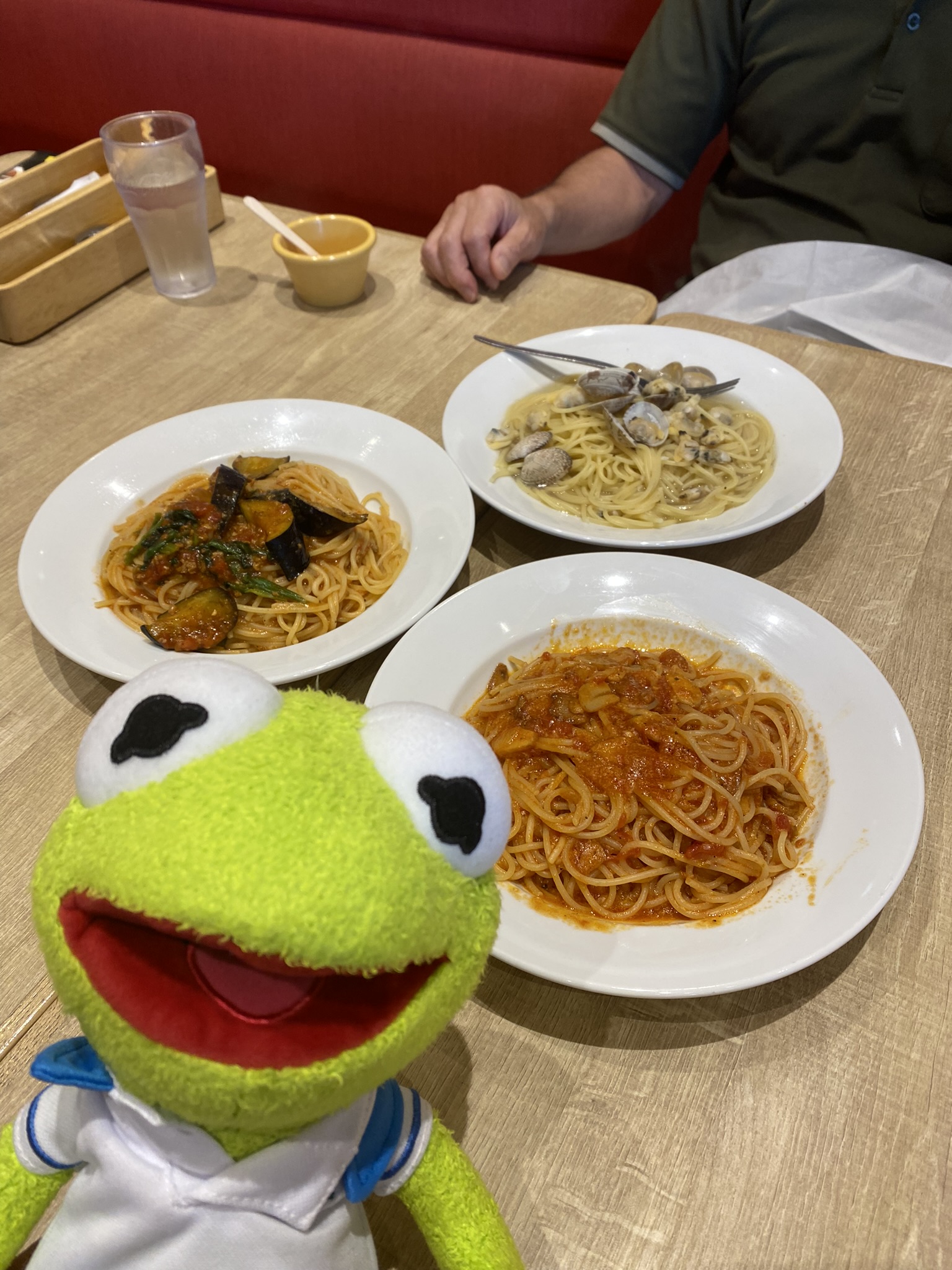 Kermit smiling next to three bowls of spaghetti.