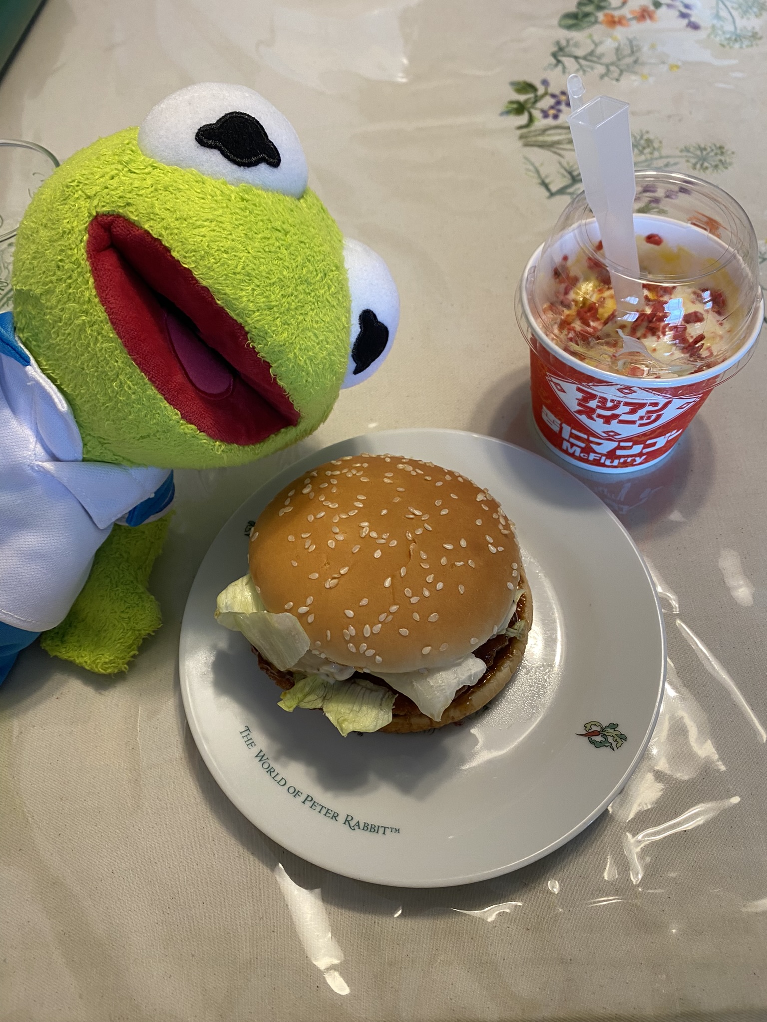 Kermit posing in front of a Garlic Butter Teriyaki Chicken McBurger and a Mango McFlurry.