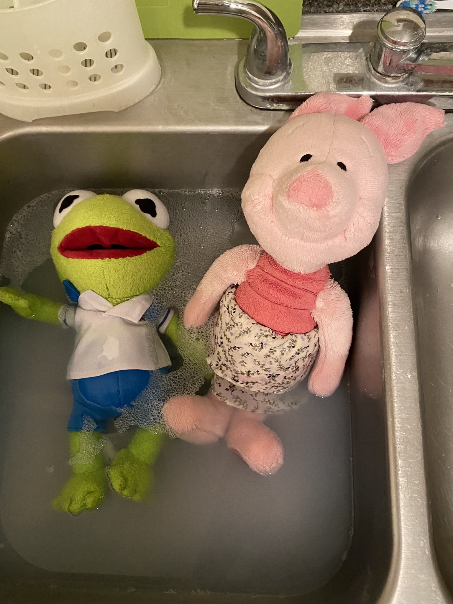 Kermit and his friend, Piglet, taking a bath in the kitchen sink.