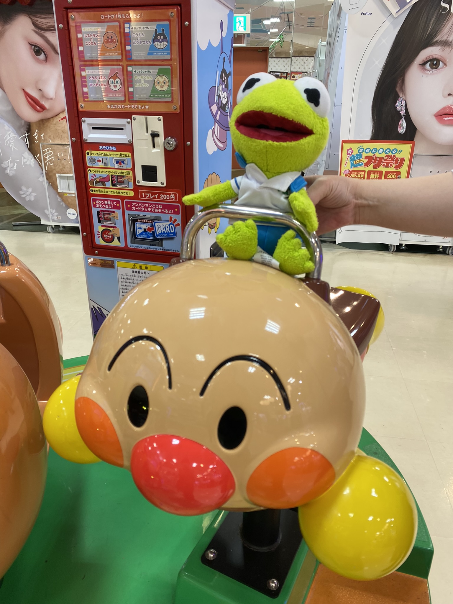 Kermit riding on the Anpanman carousel at the mall.