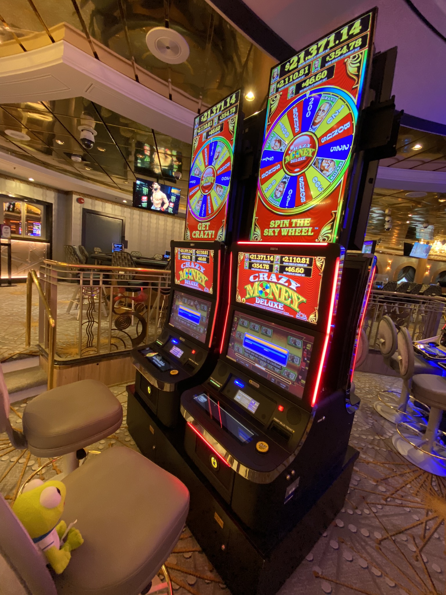 Kermit sitting in front of a gambling game called 'The Crazy Money Deluxe'.